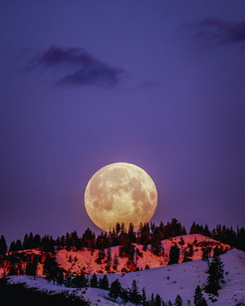 super moon over snowcapped mountain