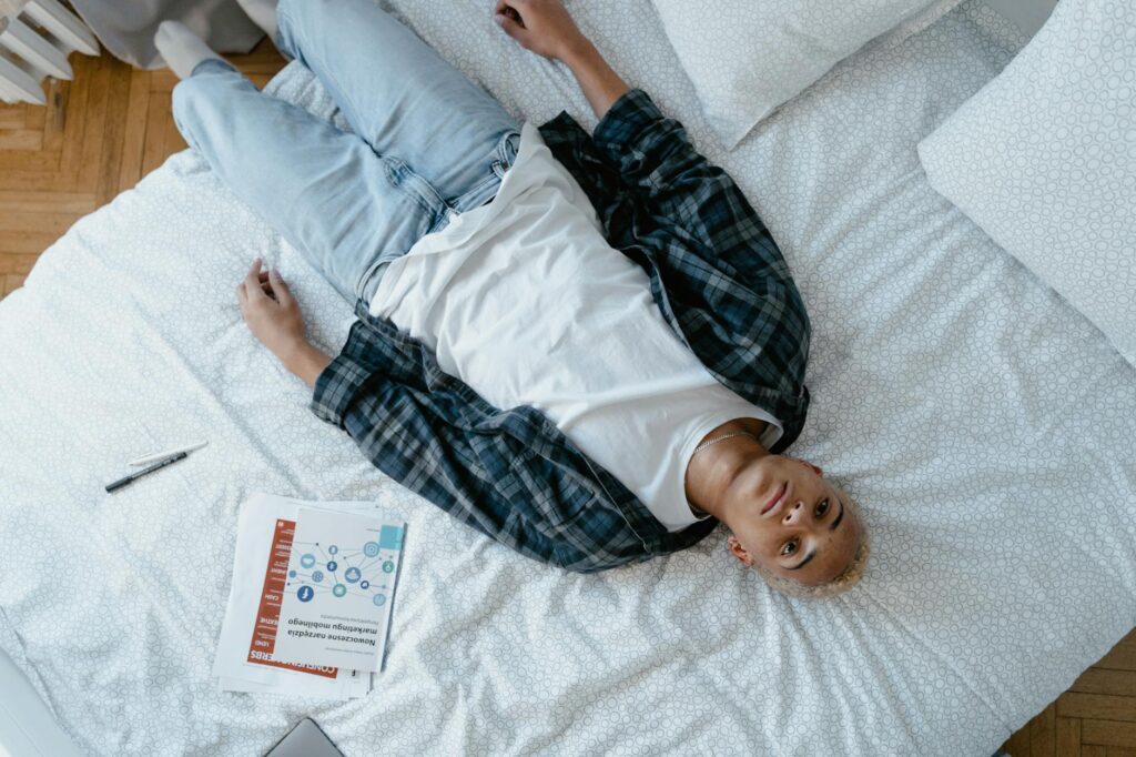 overhead shot of a young man lying in bed