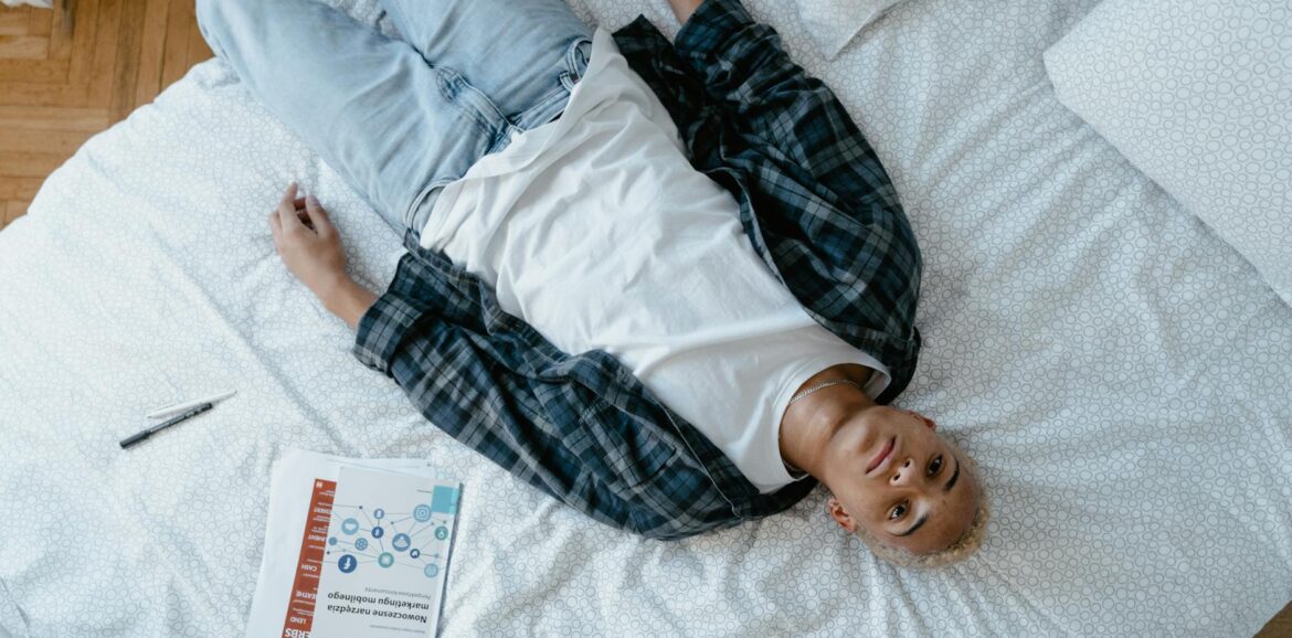 overhead shot of a young man lying in bed